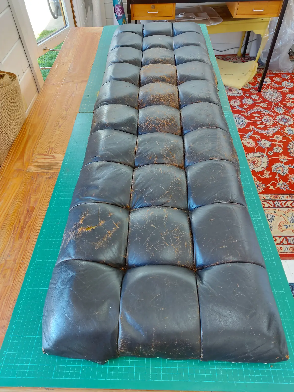 Worn black leather bench before renewal